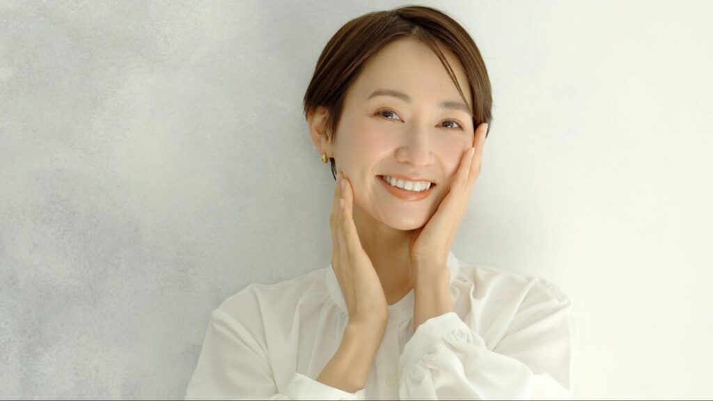 頬を押さえながら笑顔になる女性