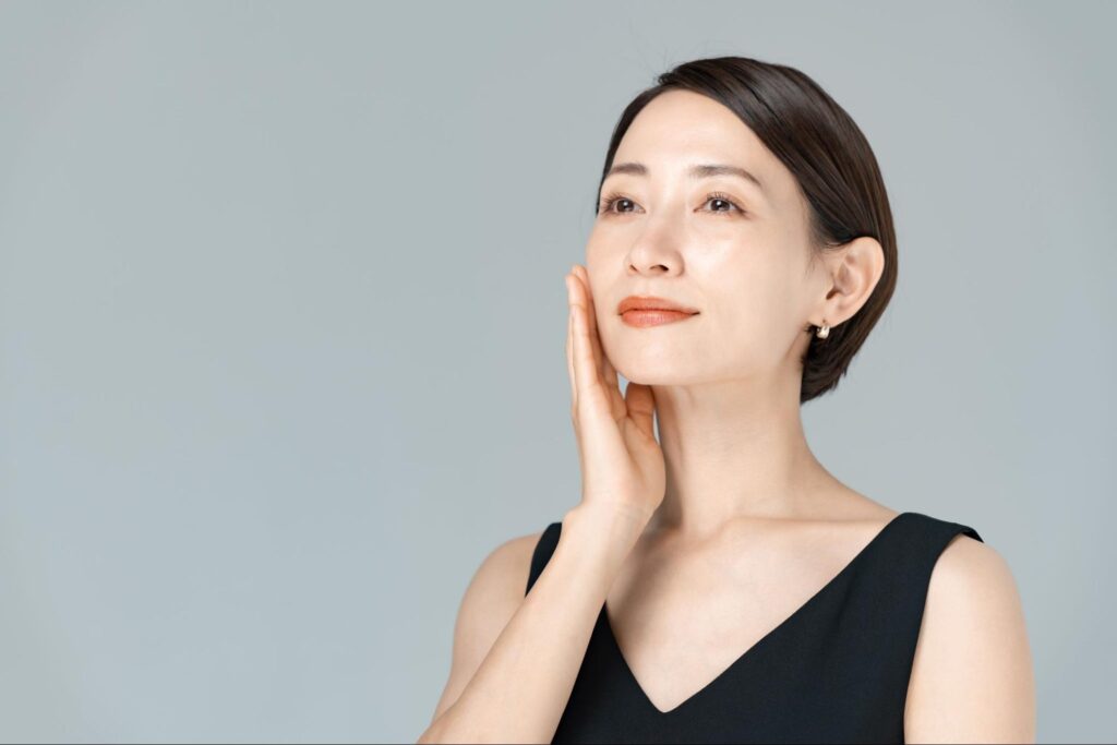 片手で頬を押さえる女性