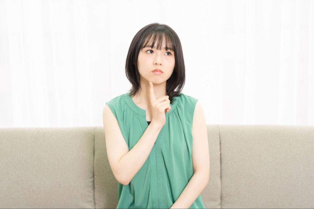 顎に人差し指を当てて考える女性