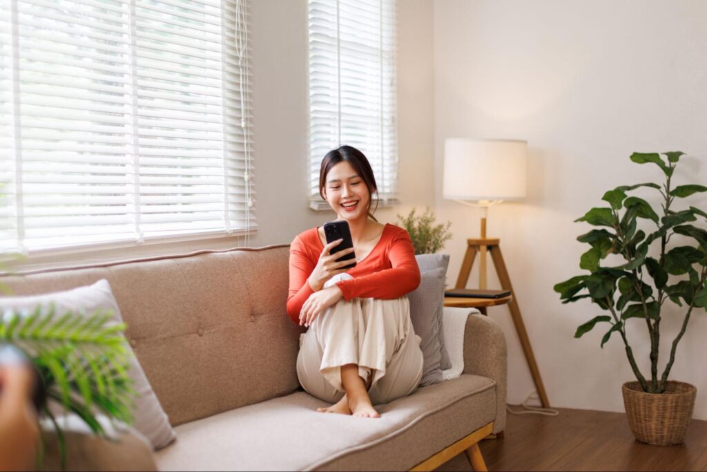 ソファでスマホを触る女性