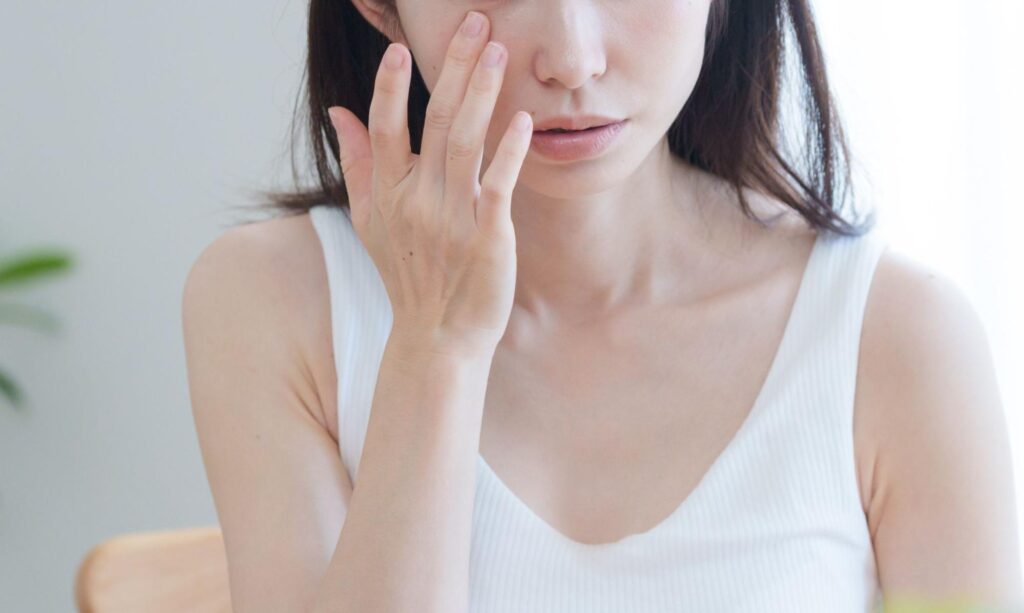 目の下を触る女性