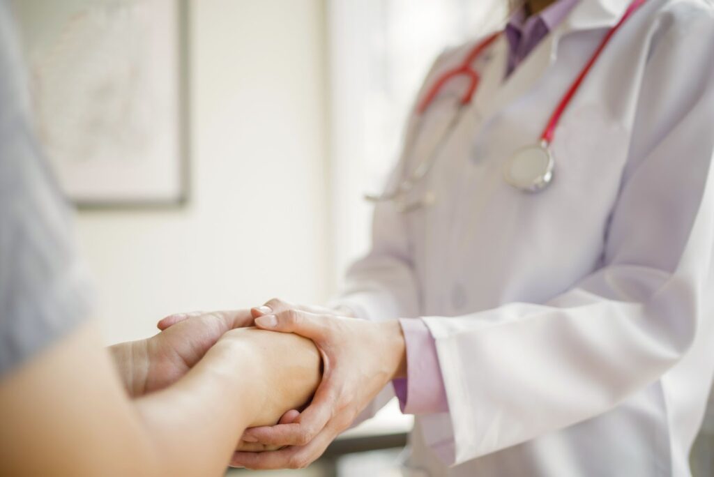 患者の手を握る医師