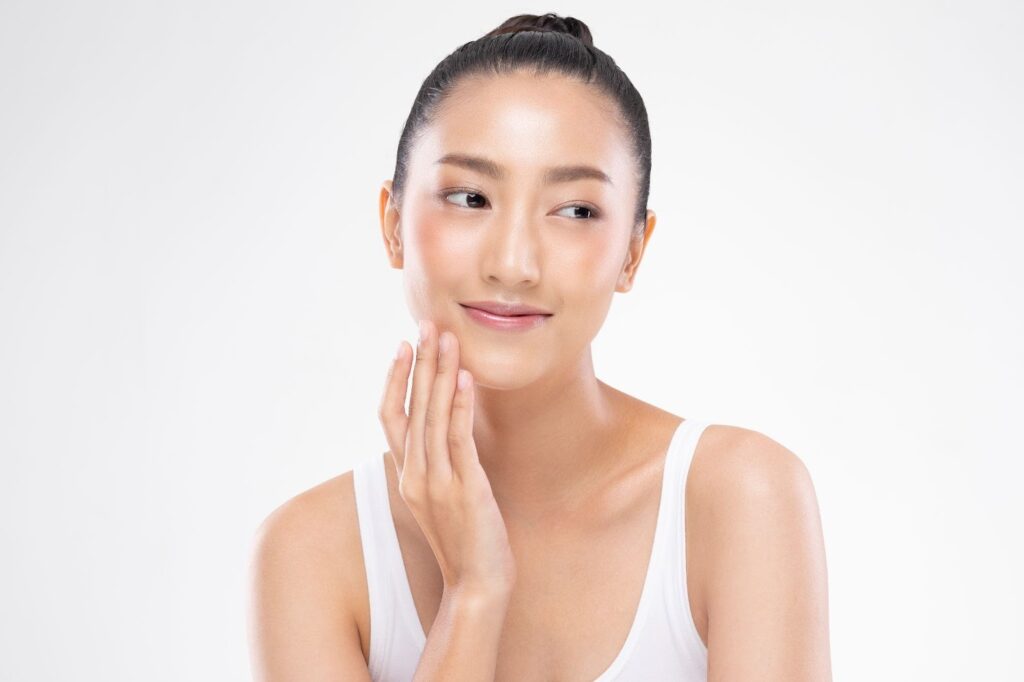 顔を触りながら目線を横に向ける女性