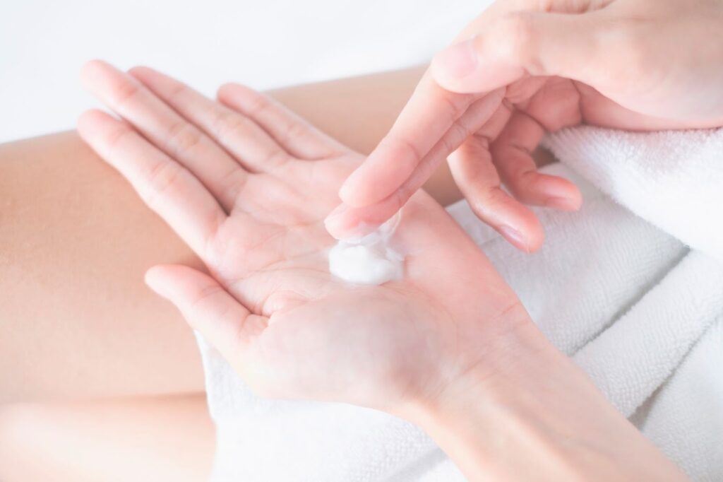 手のひらのクリームを取る指