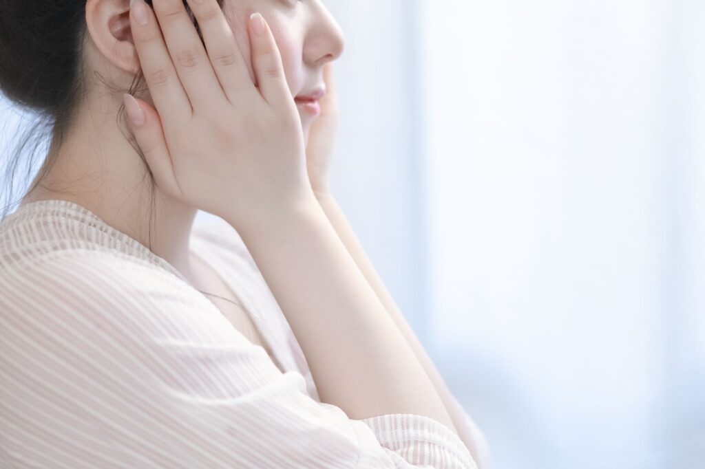 頬を押さえる女性