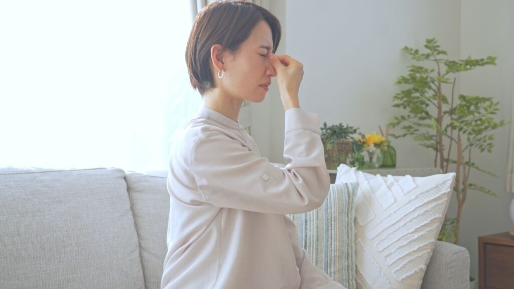 目頭を押さえる女性