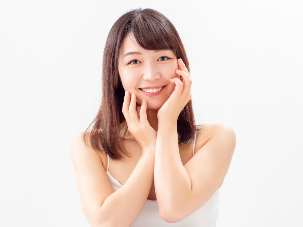 頬に手を添えて微笑む女性