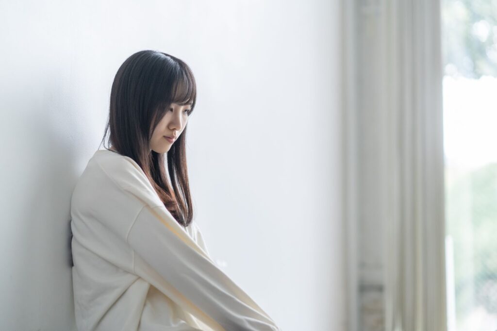 うつむいて落ち込んだ様子の女性