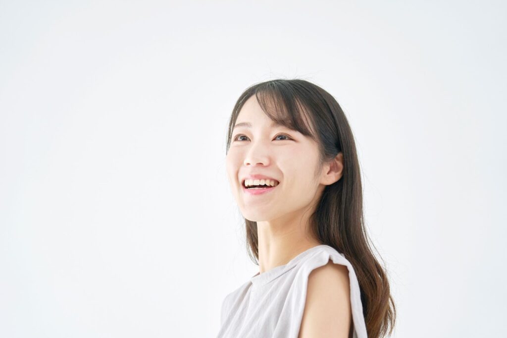斜め上を見ながら笑う女性
