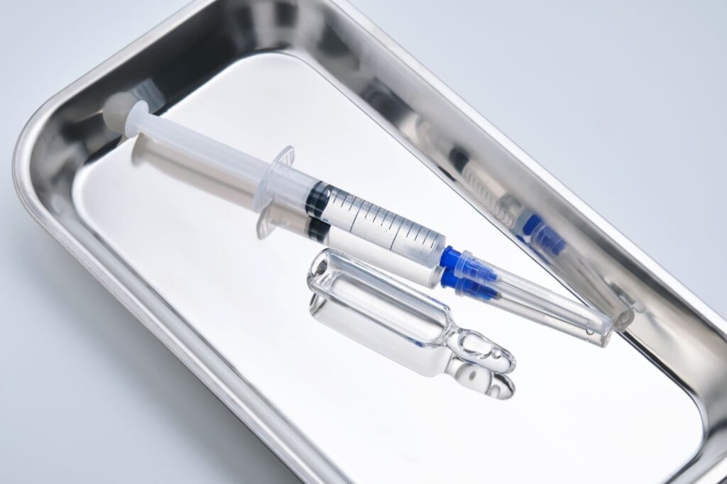 医療用トレーに置かれた注射器とアンプル