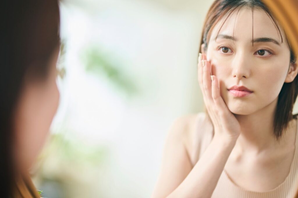 鏡で自分の顔を見る女性