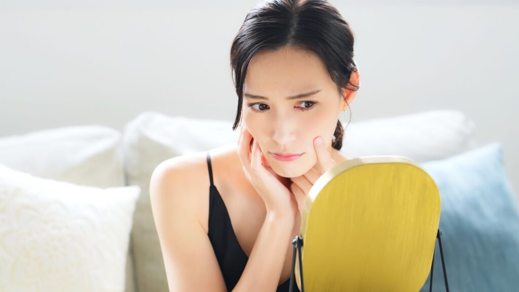 鏡を見て悩む女性