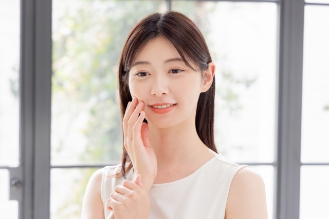 頬に手を当てて美肌を実感する女性