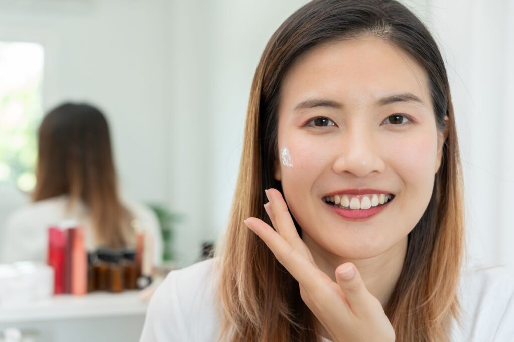 顔にスキンケアクリームをつけた女性