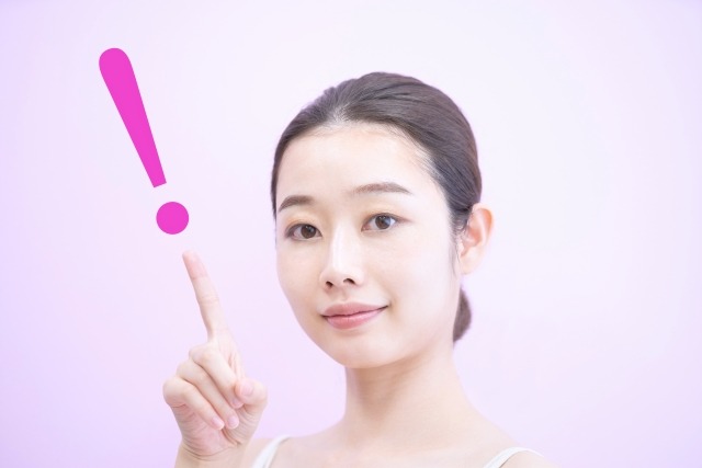 ビックリマークと人差し指を立てた女性