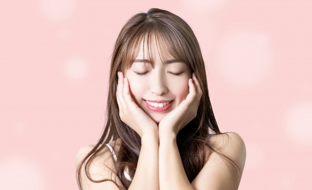 両頬を手で包み込みながら目を閉じる女性