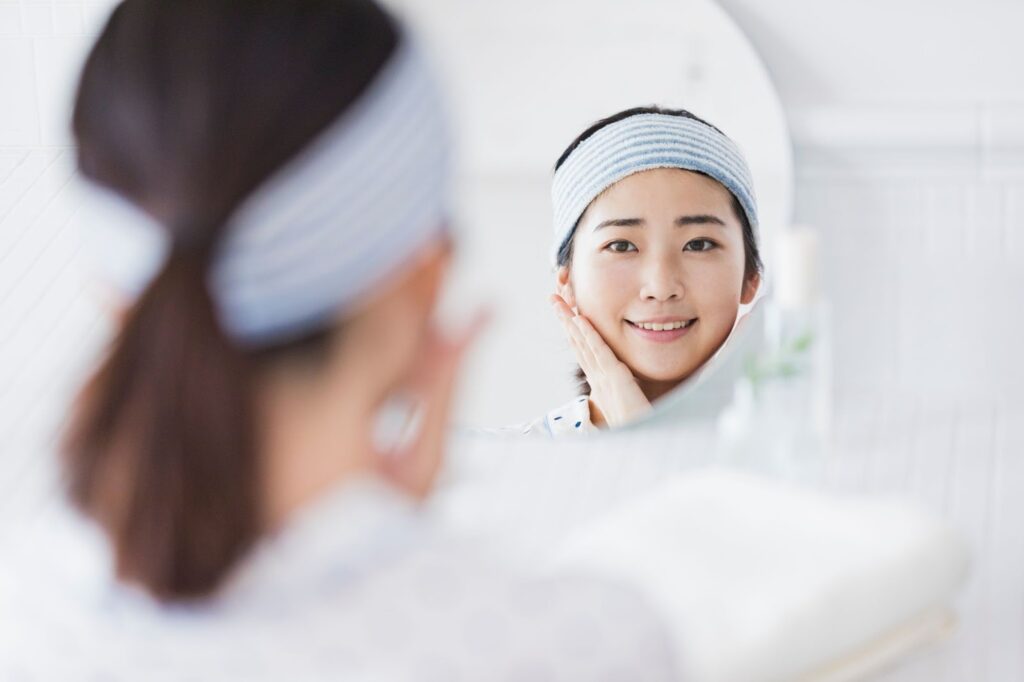 鏡で自分の顔を見る女性