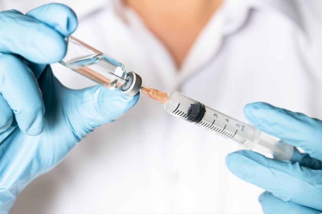 薬剤を注射器に移す手