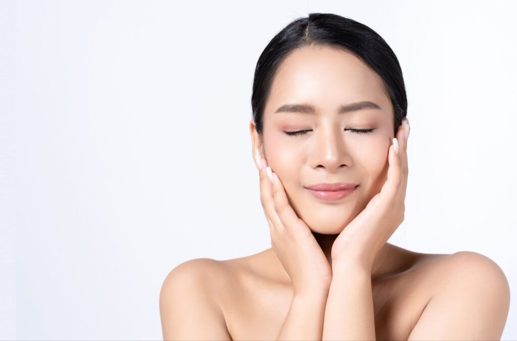 頬に手を当てて目を閉じる女性