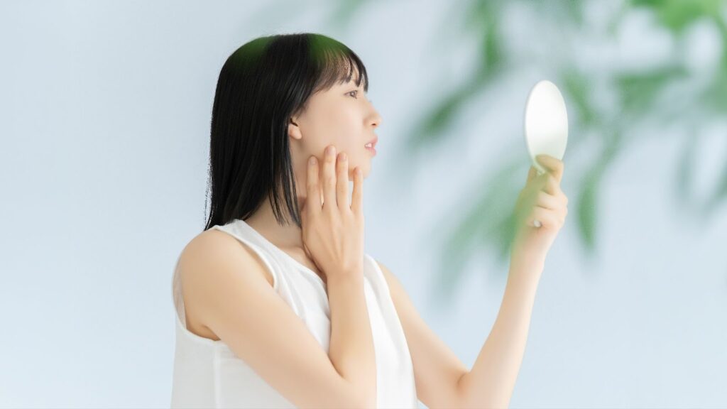 鏡で自分の顔を見る女性
