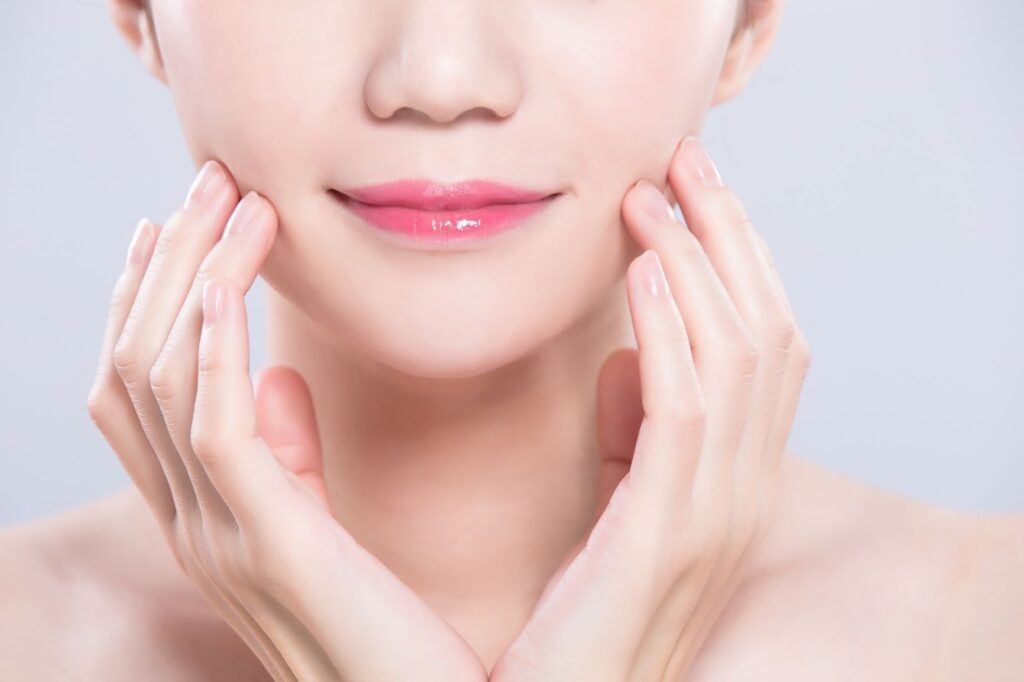 両側から頬を押さえる女性