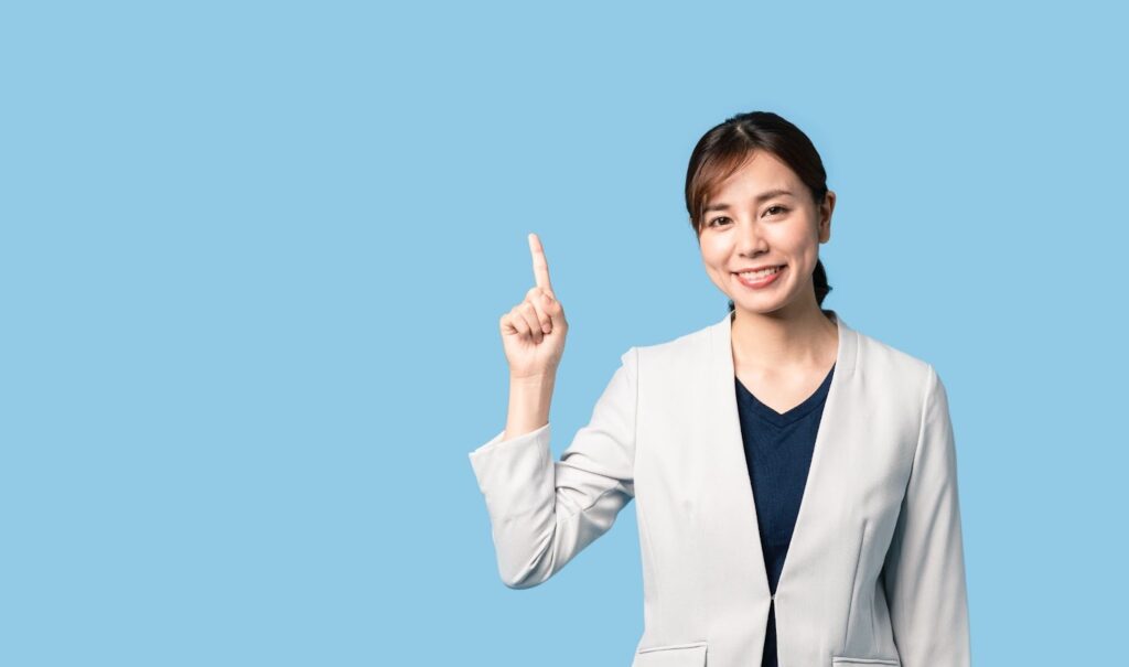 人差し指を立てる笑顔の女性