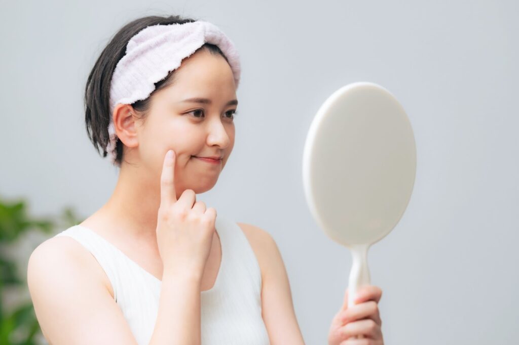 ほうれい線を気にして鏡を見ている女性
