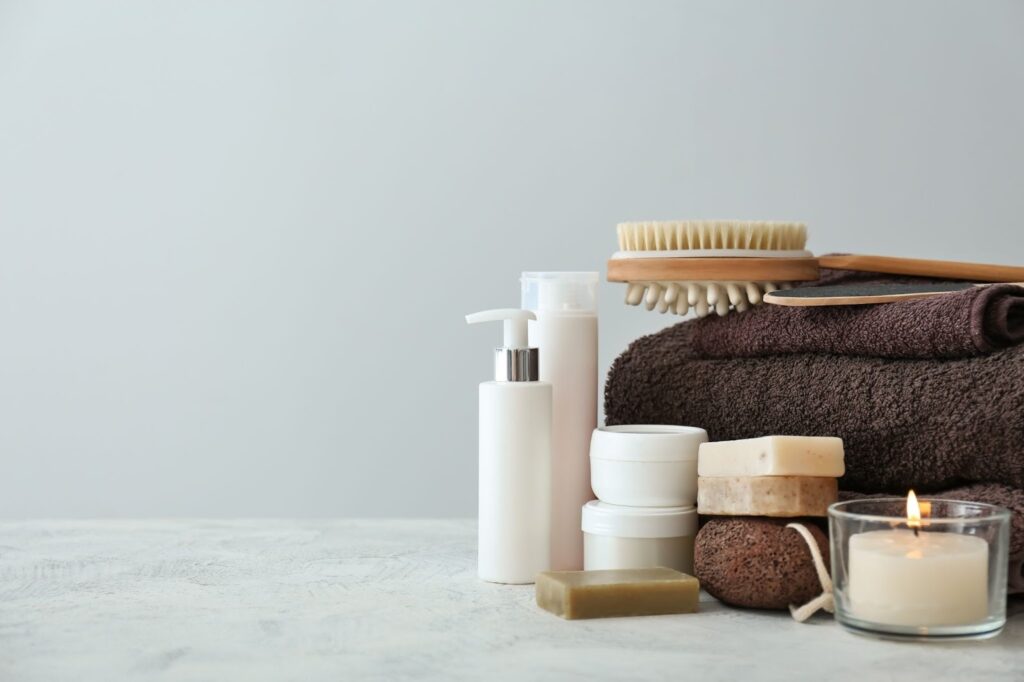 スキンケアアイテムとバスタオル、アロマキャンドル