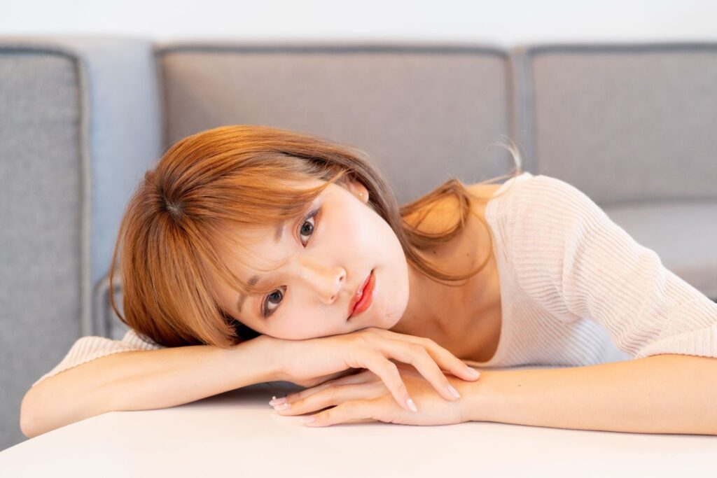 机に置いた手に顔を乗せている女性