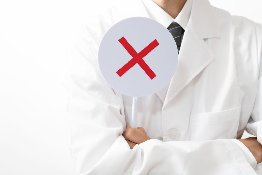 バツマークをかざす医師